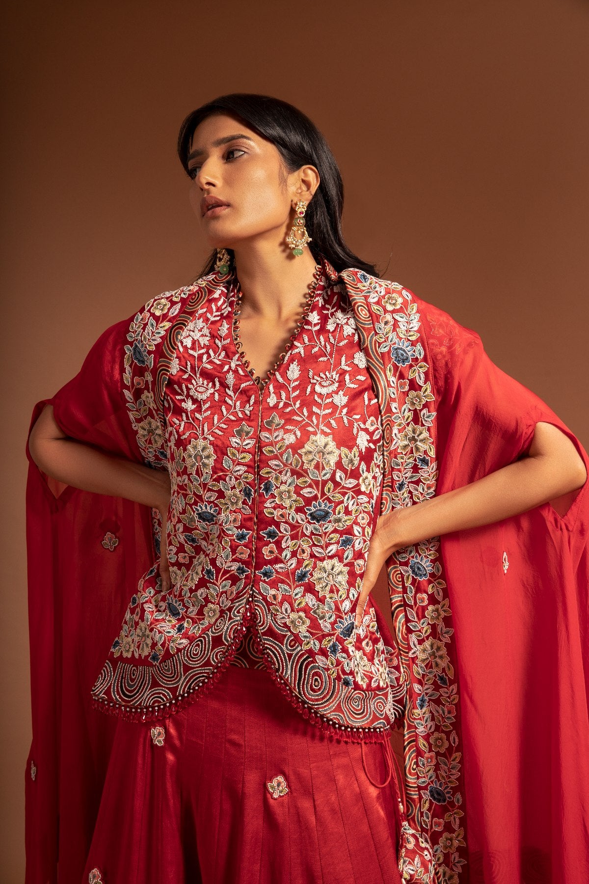 Red Lehenga and koti jacket with cape dupatta.