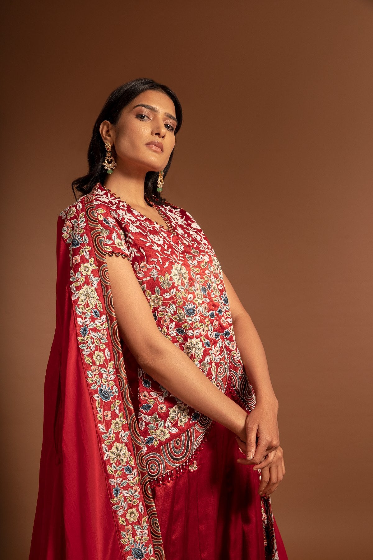 Red Lehenga and koti jacket with cape dupatta.