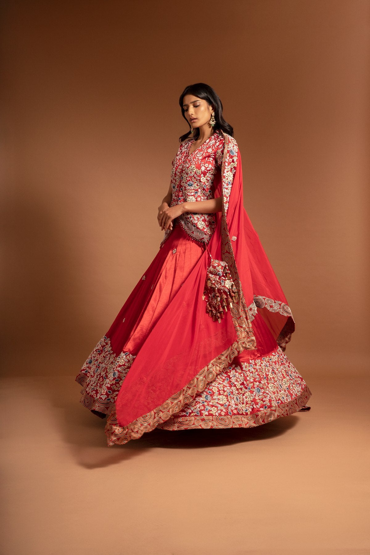 Red Lehenga and koti jacket with cape dupatta.