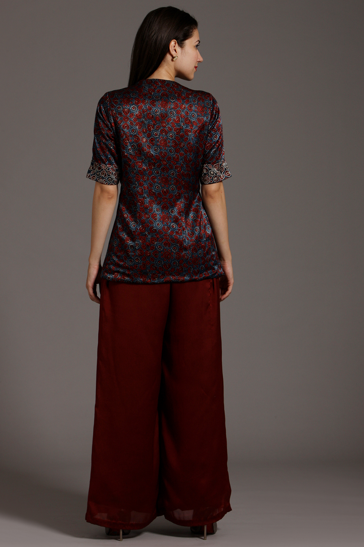 "Stunning Maroon Peplum Top in Pure Ajrakh Modal Silk with Intricate Embroidery on Yoke and Sleeves, Paired up with Maroon Pleated Pants in Crepe."