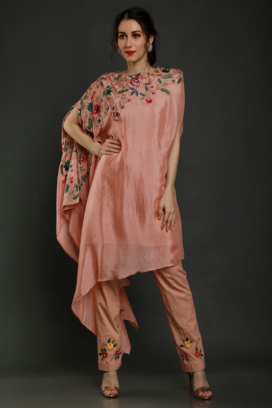 "Elegant peach crepe one-sided drape kaftan with thread, pearls & cutdana detailing, paired with stretch lycra pants - A stylish fusion outfit!"