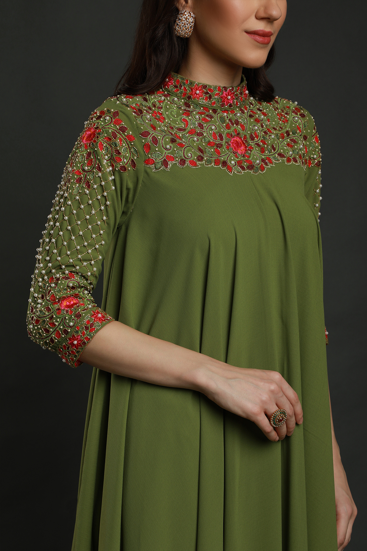 Elevate your elegance in a Mehendi Green Moss Crepe asymmetric maxi dress. Hand-embroidered with thread, pearls, and cut dana work for a unique flair.