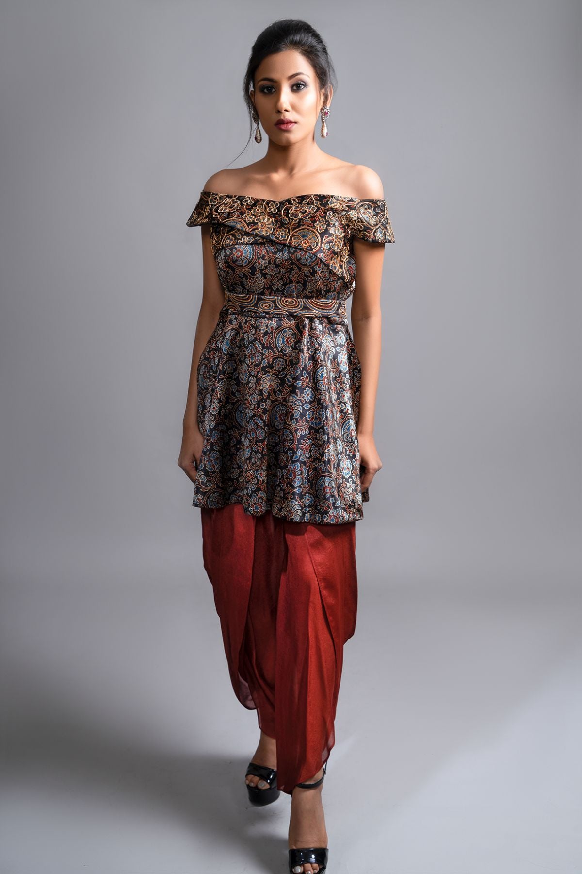 "Elegant Ajrakh Off-Shoulder Peplum Top in Pure Modal Silk with Intricate Hand Embroidery, perfectly paired with Maroon Pleated Dhoti in Pure Crepe."