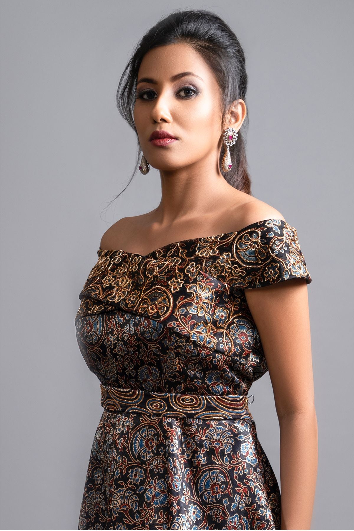 "Elegant Ajrakh Off-Shoulder Peplum Top in Pure Modal Silk with Intricate Hand Embroidery, perfectly paired with Maroon Pleated Dhoti in Pure Crepe."