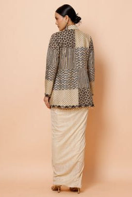 Person wearing a patterned sweater and skirt on a beige background