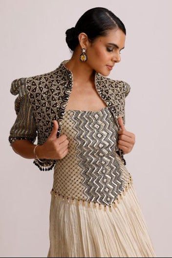Woman holding a broom with a patterned dress against a plain background