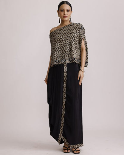 Woman wearing a patterned top and black pants with a beige background