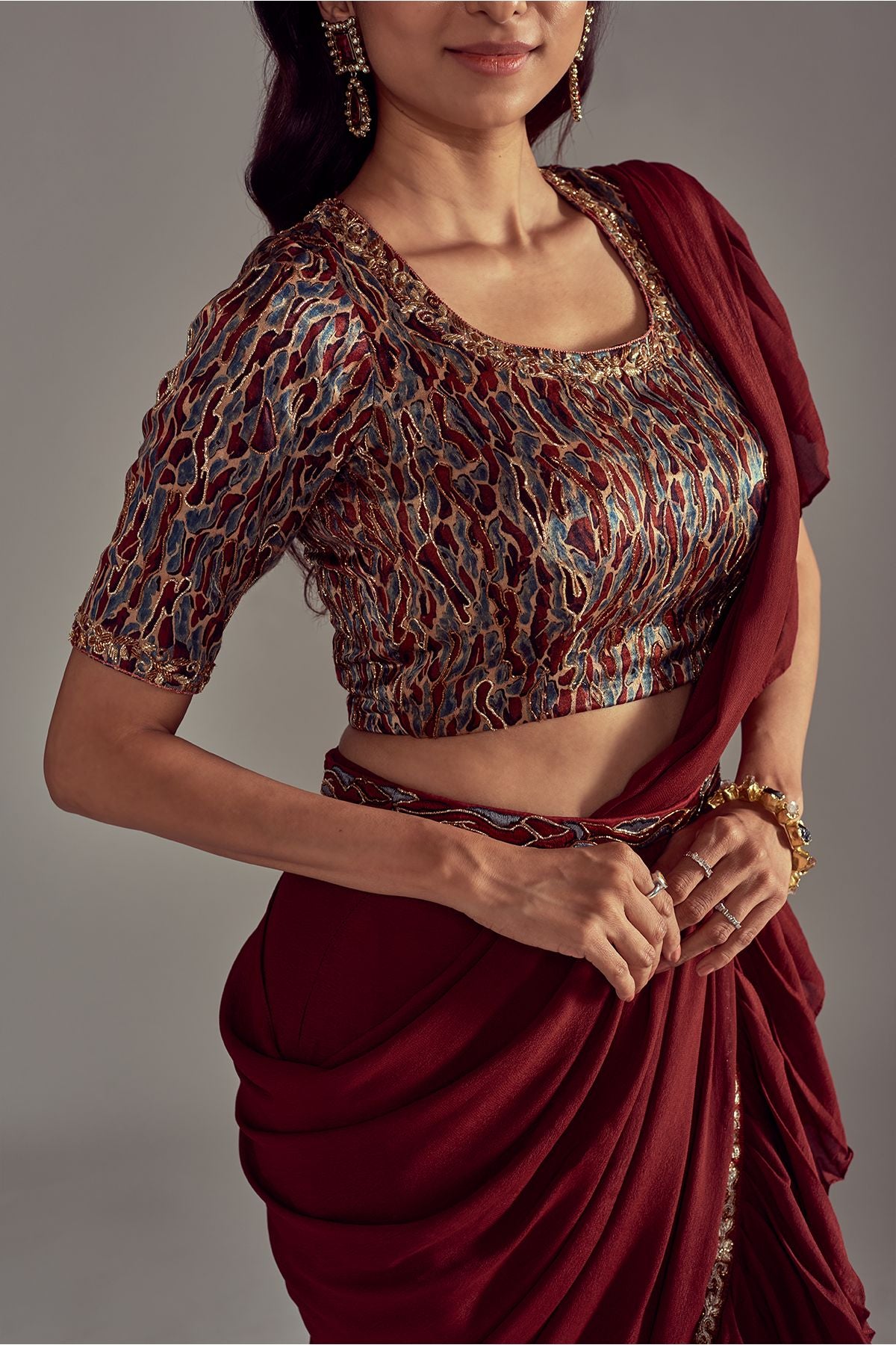 Exquisite Maroon Ruffled Saree paired with an Ajrakh Printed Blouse featuring Intricate Embroidery in Mashru Silk, complemented by a Fully Handcrafted Waistband