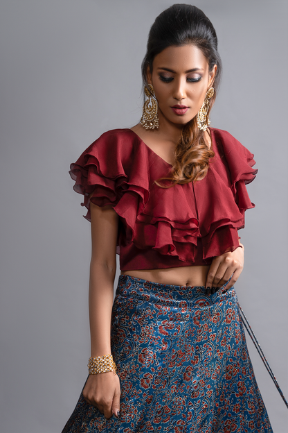 "Explore the allure of indigo Ajrakh print mashru silk lehenga with zardosi & Nakshi embroidery, paired with ruffled blouse & blue organza dupatta"