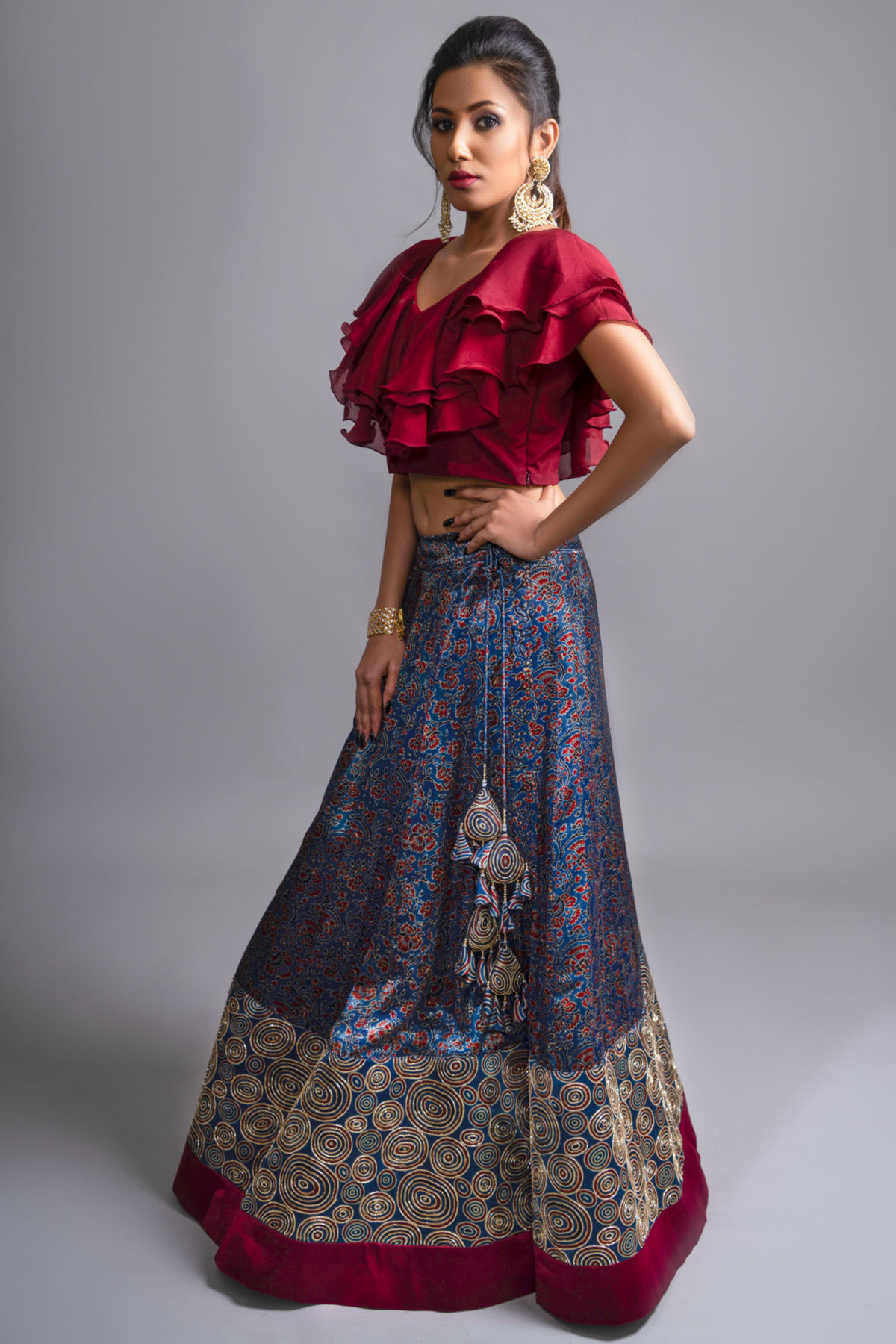 "Explore the allure of indigo Ajrakh print mashru silk lehenga with zardosi & Nakshi embroidery, paired with ruffled blouse & blue organza dupatta"
