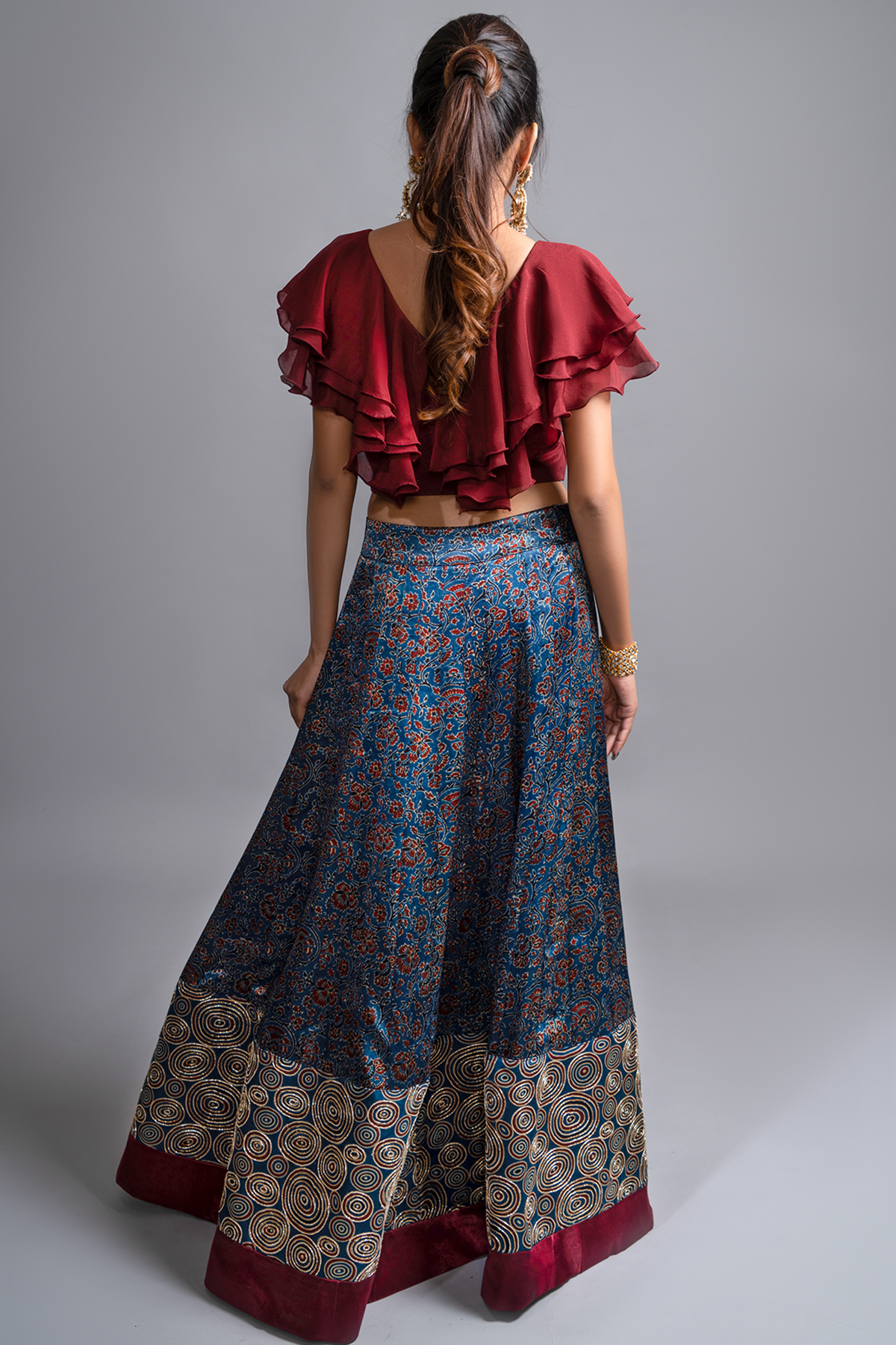 "Explore the allure of indigo Ajrakh print mashru silk lehenga with zardosi & Nakshi embroidery, paired with ruffled blouse & blue organza dupatta"